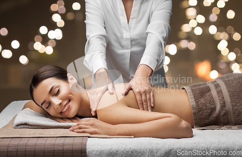 Image of woman lying and having back massage at spa