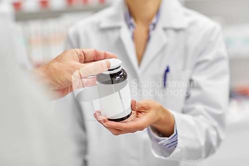 Image of pharmacist and customer with medicine at pharmacy