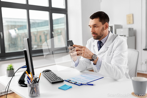 Image of male doctor with smartphone at hospital