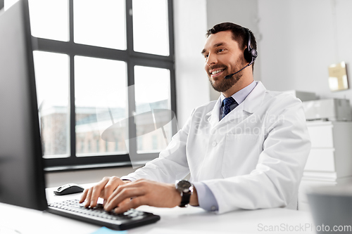 Image of happy doctor with computer and headset at hospital