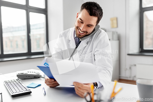 Image of male doctor calling on desk phone at hospital