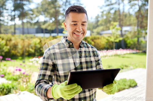 Image of man with tablet pc at summer garden