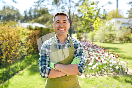 Image of happy man in apron at summer garden