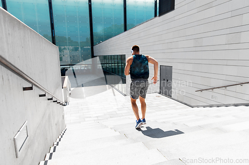 Image of young man in headphones running downstairs