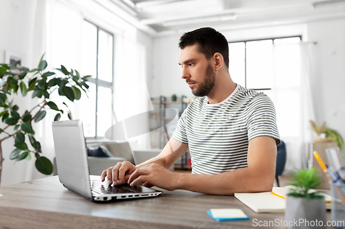 Image of man with laptop working at home office
