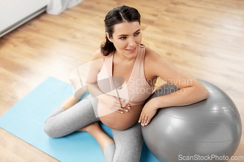 Image of happy pregnant woman with fitball at home