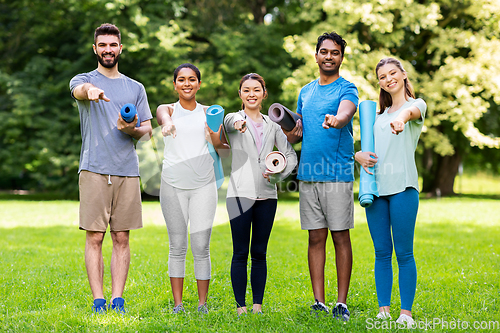 Image of group of happy people with yoga mats at park