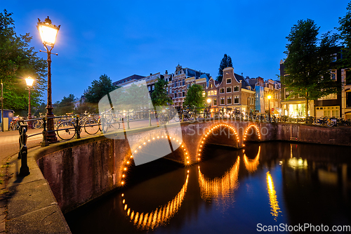 Image of Amterdam canal, bridge and medieval houses in the evening