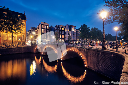 Image of Amterdam canal, bridge and medieval houses in the evening