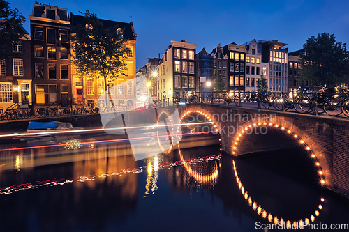 Image of Amterdam canal, bridge and medieval houses in the evening