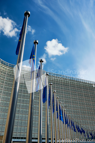 Image of EU European Union flags in front of European Comission building in Background. Brussles, Belgium