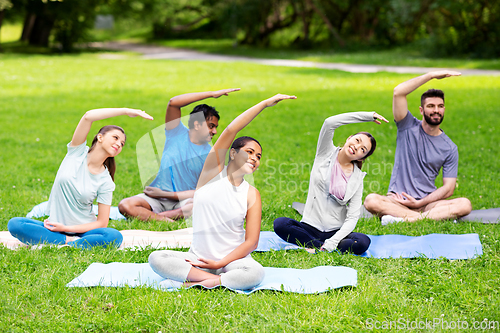 Image of group of people exercising at summer park