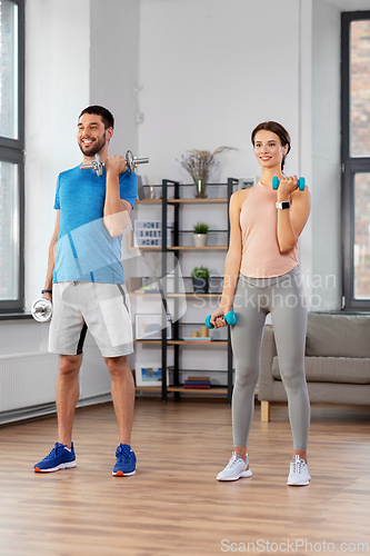 Image of happy couple exercising at home