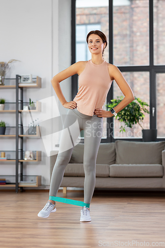 Image of woman exercising with resistance band at home