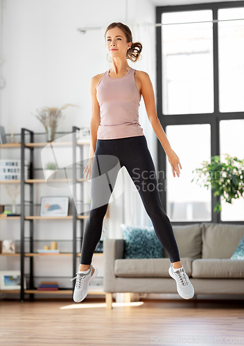 Image of young woman exercising at home