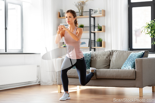 Image of young woman exercising at home