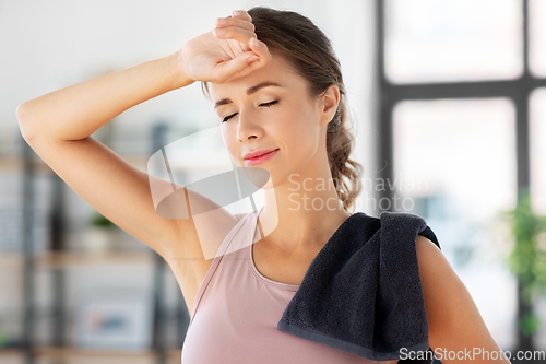 Image of tired young woman with towel after fitness at home