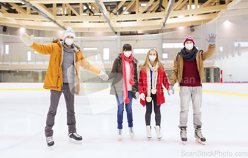 Image of friends in masks waving hands on skating rink
