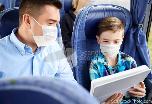 Image of family in masks with tablet pc in travel bus