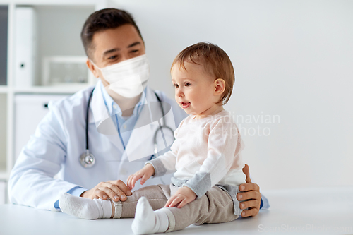 Image of doctor or pediatrician in mask with baby at clinic