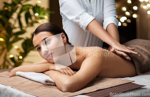 Image of woman lying and having back massage at spa