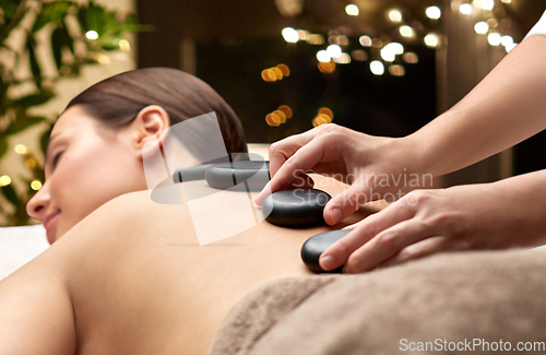 Image of close up of woman having hot stone massage at spa