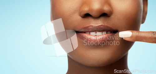 Image of african american woman pointing to her mouth