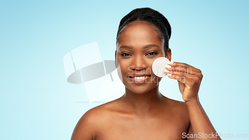 Image of african woman cleaning face with cotton pad