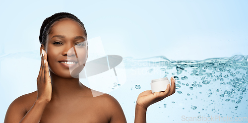 Image of smiling african american woman with moisturizer