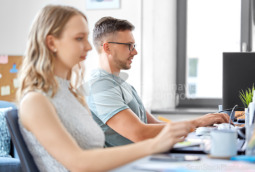 Image of male creative worker with laptop working at office