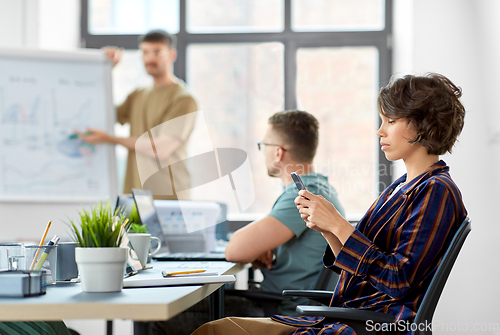 Image of woman with smartphone at office conference