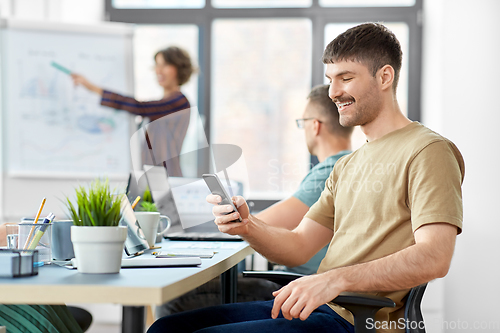 Image of happy man with smartphone at office conference