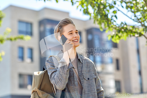 Image of teenage student boy calling on smartphone in city