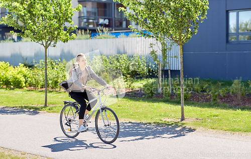 Image of young man riding bicycle on city street