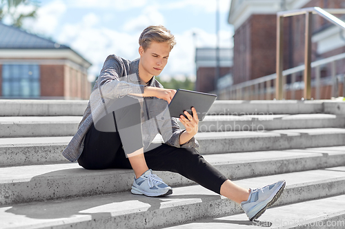 Image of young manor teenage boy with tablet pc in city