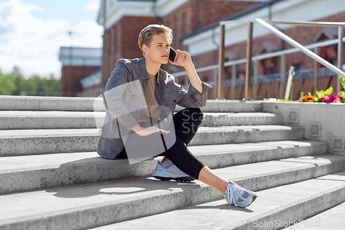 Image of teenage boy calling on smartphone in city