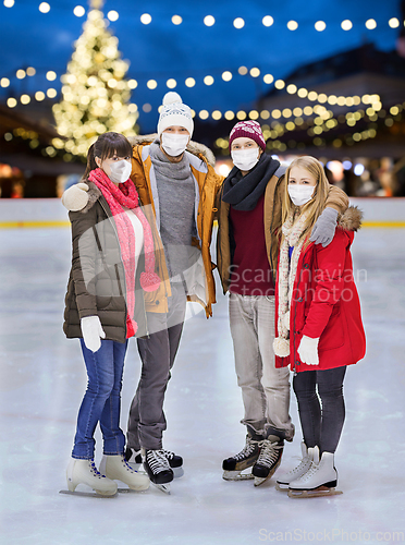 Image of friends in masks at christmas skating rink