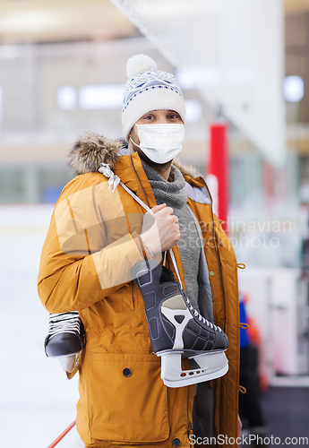 Image of young man in mask with ice-skates on skating rink