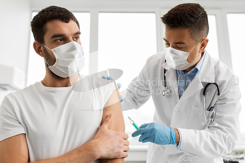 Image of patient and doctor in masks doing vaccination