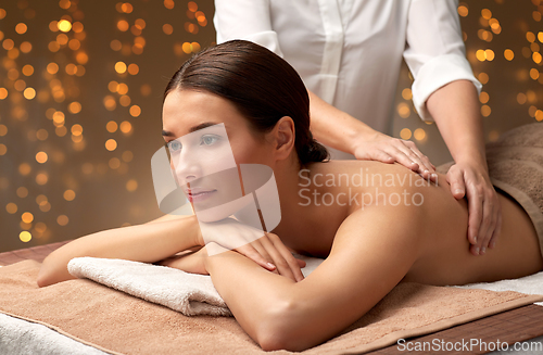 Image of woman lying and having back massage at spa