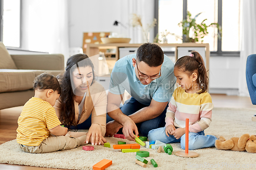 Image of happy family palying with wooden toys at home