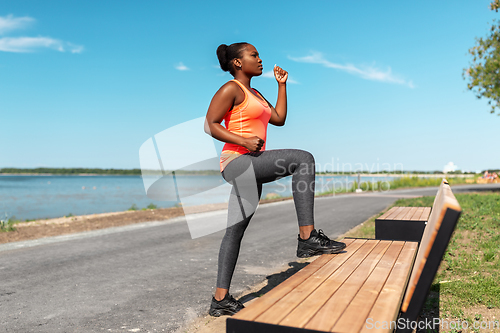 Image of african american woman doing sports at seaside