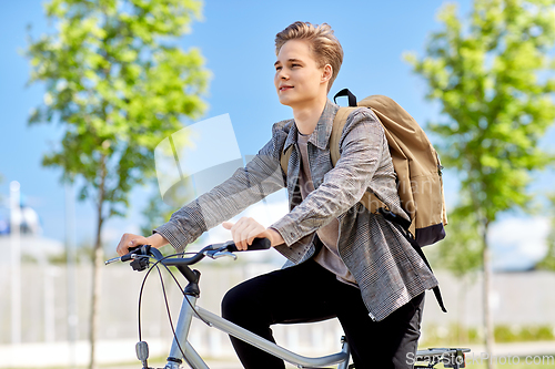 Image of young man riding bicycle on city street