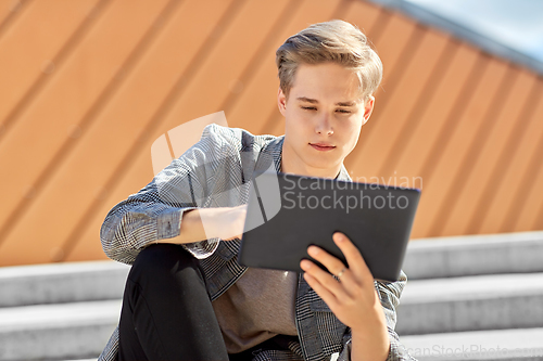 Image of young manor teenage boy with tablet pc in city