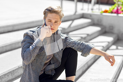 Image of teenage boy calling on smartphone in city