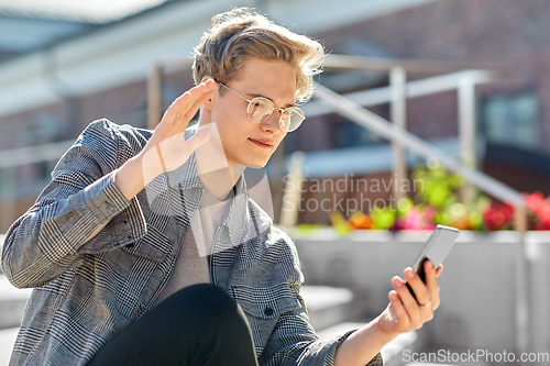 Image of teenage boy with smartphone having video call