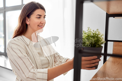 Image of woman decorating home with flower or houseplant