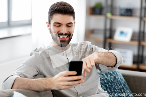 Image of man in earphones listening to music on smartphone