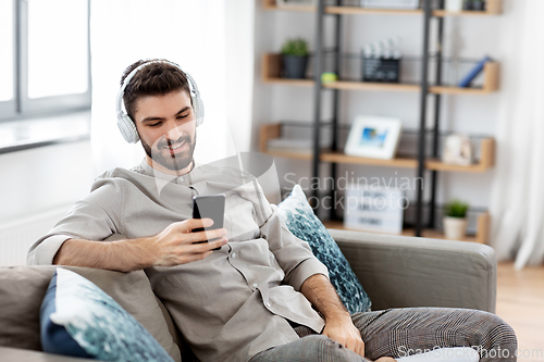 Image of man in headphones listening to music on smartphone