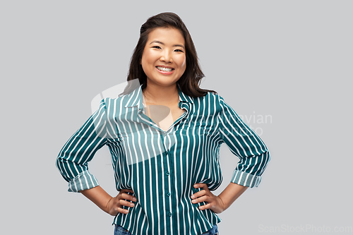 Image of happy asian woman over grey background